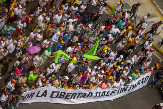 TENSIN. Grupos opositores al Gobierno venezolano recorren las calles de Caracas, ayer.