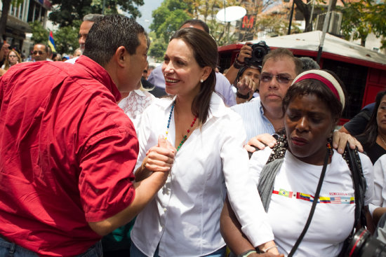 DENUNCIA. Mara Corina Machado (c) recibe el apoyo de sus seguidores en Caracas.