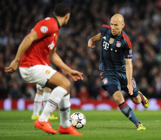 Arjen Robben (d), del Bayern, trata de burlar a Rio Ferdinand.