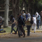 DISTURBIOS. Un hombre es atacado durante una protesta contra el Gobierno, ayer.