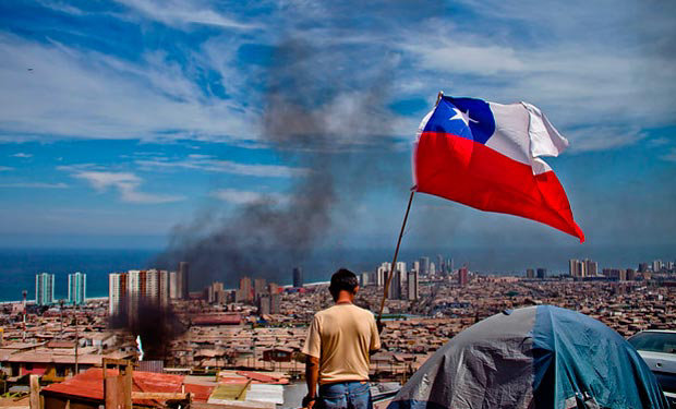 VCTIMAS. Uno de los civiles damnificados por el terremoto ondeando la bandera de Chile.