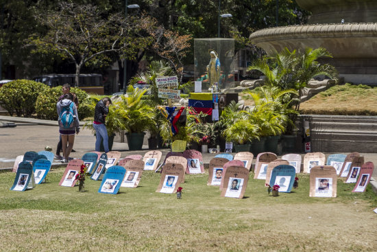 DENUNCIA. Unas lpidas hechas de cartn con fotografas de los fallecidos en las protestas venezolanas son vistas en la Plaza Altamira de Caracas, ayer.