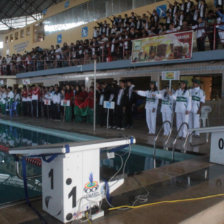 El acto inaugural de ayer, en la piscina de El Rollo; abajo, la partida de un grupo de nadadoras.