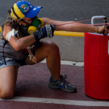 PROTESTAS. Una manifestante opositora lanza piedras contra un grupo de policas en Caracas.