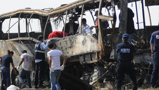 SINIESTRO. Autoridades recuperan los restos de las vctimas en el autobs accidentado.