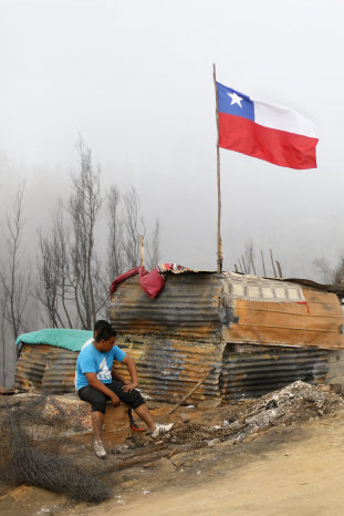 RECONSTRUCCIN. Un hombre se sienta junto a un refugio temporal en el cerro la Cruz.