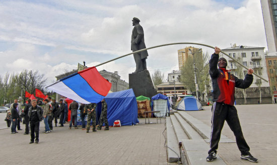 SEPARATISMO. Un manifestante prorruso ondea una bandera rusa junto al monumento a Vladimir Ilich Ulianov, Lenin, en una plaza de la ciudad de Donetsk, Ucrania.