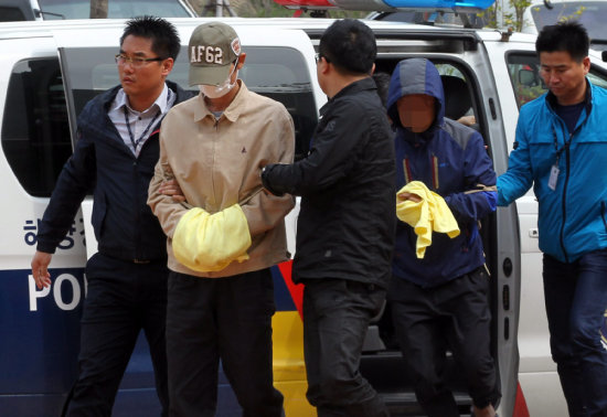 DETENCIONES. Marineros del naufragado ferri surcoreano Sewol llegan a la corte de Mokpo dentro de las investigaciones del accidente.