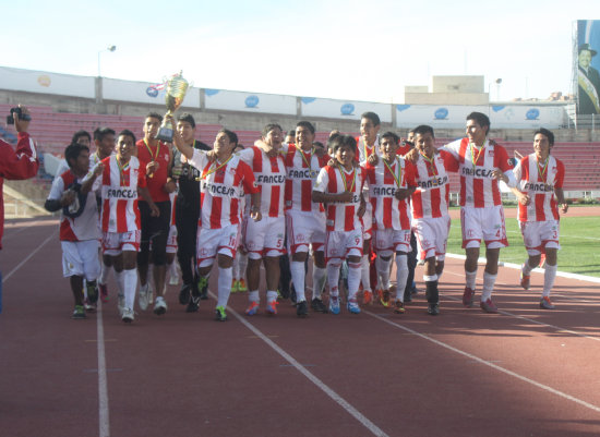 La celebración de los campeones dando la vuelta olímpica con su trofeo.