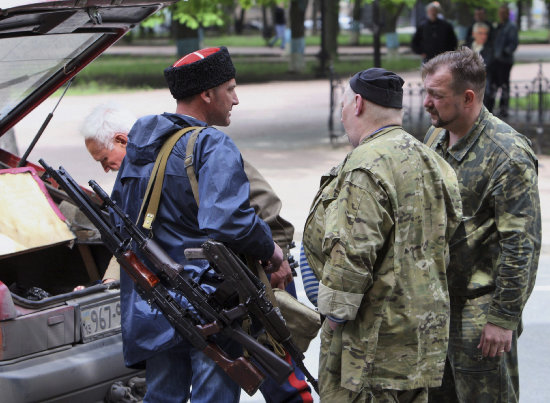 ENFRENTAMIENTOS. Activistas prorrusos cargan armamento en un coche en la localidad de Lugansk, Ucrania, ayer lunes.