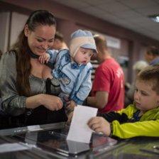 REFERNDUM. Una mujer emite su voto junto a su hijo en un centro electoral de la rebelde Lugansk, durante la consulta popular de ayer.