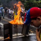 PROTESTA. Manifestantes opositores prenden fuego a una barricada en Caracas.