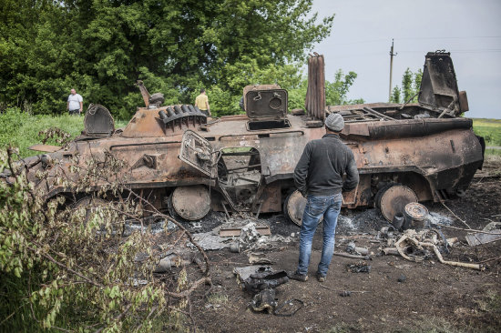 TENSIN. Un jven examina un vehculo militar ucraniano derribado en un poblado cerca de Kramatorsk, Ucrania.