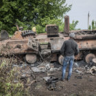 TENSIN. Un jven examina un vehculo militar ucraniano derribado en un poblado cerca de Kramatorsk, Ucrania.