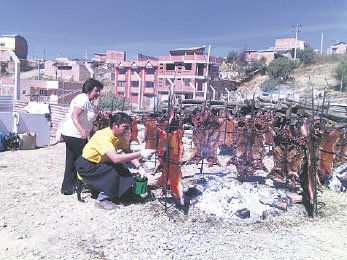 PACIENCIA. Los asadores hacen cocer un chanchito a la cruz en unas seis horas.