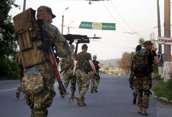 REBELIN. Insurgentes prorrusos recorren una calle de la ciudad tomada de Slaviansk.