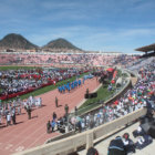 Miles de estudiantes asistieron al acto inaugural; abajo, deportistas llevan la antorcha al pebetero.