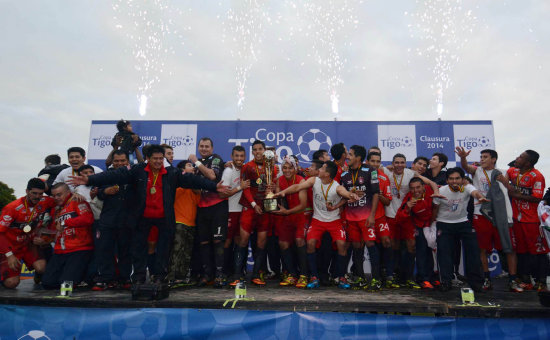 Los jugadores y cuerpo tcnico de Universitario celebran con la copa de campen del Torneo Clausura, logrado ayer, en el estadio Samuel Vaca Jimnez, de Warnes.