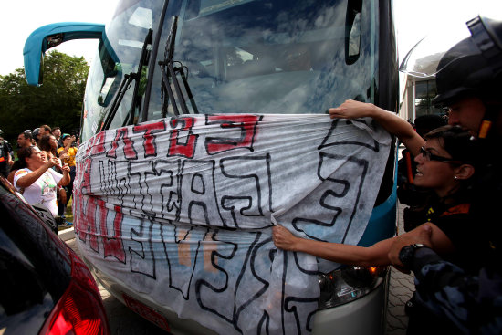 Las protestas en Brasil se enfatizaron con el inicio del trabajo de la seleccin carioca; abajo, el delantero Fred firma la polera de un aficionado.