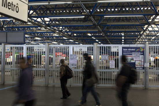 Algunas personas caminan junto a una estacin de metro cerrada por la huelga de los trabajadores.