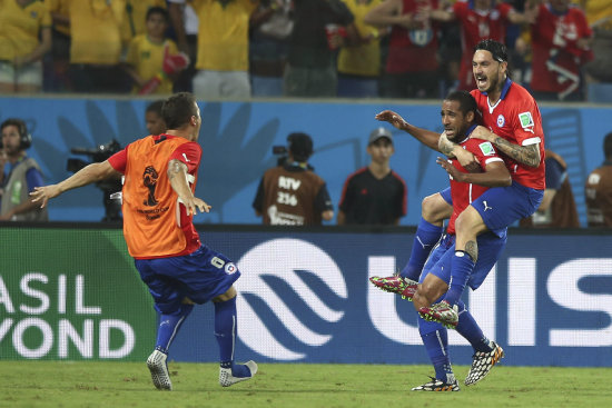 Jean Beausejour (2d) es alcanzado por dos compaeros para fundirse en un abrazo tras marcar el tercer gol.