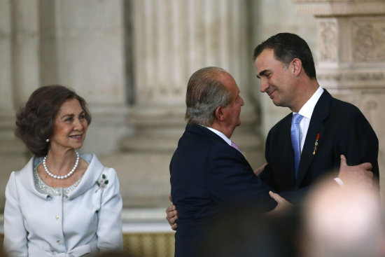 CEREMONIA. El Rey Juan Carlos abraza al Prncipe de Asturias, Felipe de Borbn, junto a la Reina Sofa, tras firmar la ley de abdicacin.