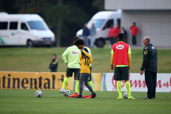 El jugador brasileo Willian (i) abraza una nia que invadi la cancha del seleccionado de Brasil.