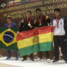 El boliviano Mohamed Dames celebra en el podio tras colgarse la medalla de oro; al lado, otro de los bolivianos que gan una medalla de plata.