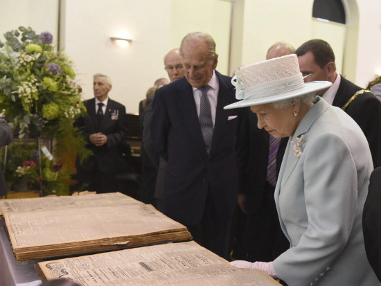 HISTORIA. La reina Isabell II de Inglaterra y su marido revisan los peridicos que reflejan la guerra.