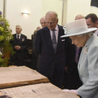 HISTORIA. La reina Isabell II de Inglaterra y su marido revisan los peridicos que reflejan la guerra.