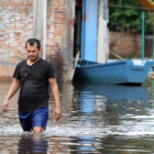 AFECTADOS. Un hombre camina por una calle inundada en el barrio Sajonia de Asuncin. .