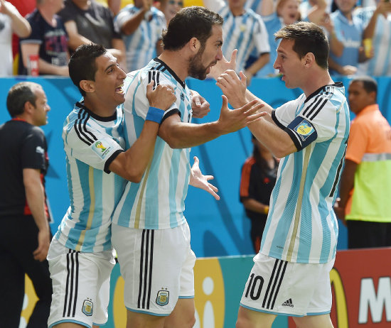 Gonzalo Higuan (c) festeja el gol junto a sus compaeros ngel Di Mara (i) y Lionel Messi; abajo, el belga Toby Alderweireld y el argentino Rodrigo Palacio luchan por un baln.