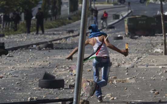 DISTURBIOS. Un manifestante palestino tira un cocktail Molotov en Gaza.