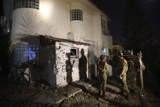 ATAQUES. Soldados israeles inspeccionan los impactos provocados por un misil lanzado desde Palestina sobre una vivienda cerca de la frontera.