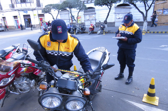 SANCIN MORAL. Los guardias municipales de trnsito colocan pegatinas.