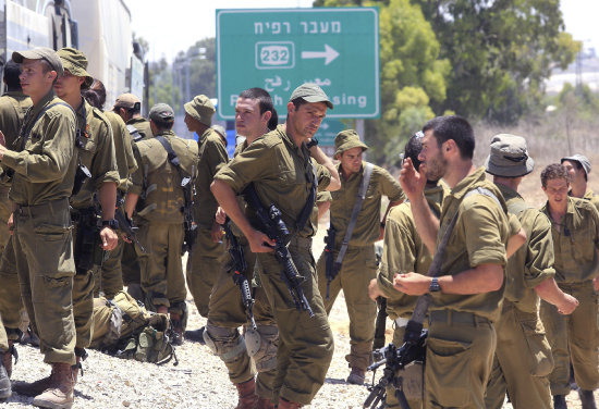 MOVILIZADOS. Varios reservistas israeles esperan en un puesto militar fronterizo.