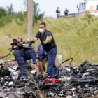 DESASTRE. Trabajadores ucranianos remueven los restos del avin de Malasyan Airlines que cay el jueves sobre una zona de Donetsk.