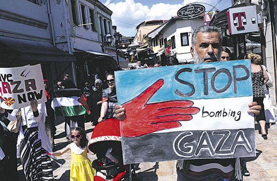 PROTESTA. Ciudadanos macedonios sostienen banderas palestinas y pancartas durante una protesta contra la ofensiva israel en Gaza.