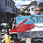 PROTESTA. Ciudadanos macedonios sostienen banderas palestinas y pancartas durante una protesta contra la ofensiva israel en Gaza.