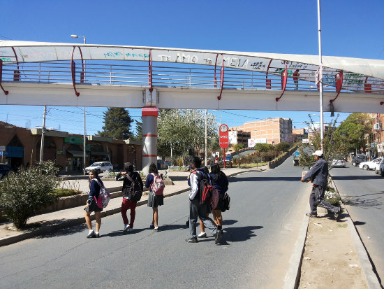 RIESGO. Un grupo de estudiantes cruza las avenidas Jaime y Germn Mendoza, por debajo de la pasarela, sin inmutarse del peligro que corre.