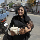 GUERRA. Una mujer palestina lleva a un nio en brazos despus de un ataque areo israel sobre la localidad de Rafah, en el sur de Gaza.