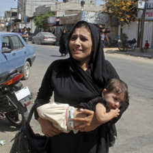 GUERRA. Una mujer palestina lleva a un nio en brazos despus de un ataque areo israel sobre la localidad de Rafah, en el sur de Gaza.