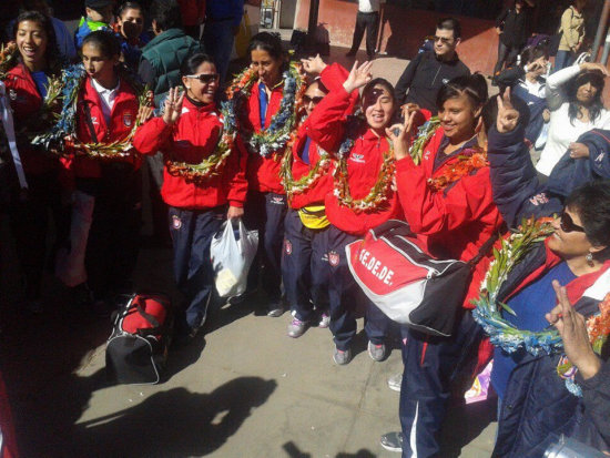 Las jugadoras chuquisaqueas se emocionaron al momento de bajar del autobs; abajo, la entrenadora Sulema Vallejos muestra el trofeo.