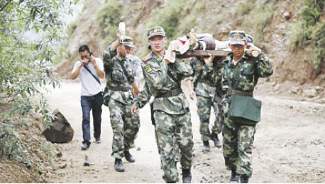 RESCATE. Soldados chinos rescatan a un herido de la zona del terremoto.