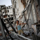 DESASTRE. Un niño palestino juega en los escombros de una torre metálica en la Franza de Gaza.