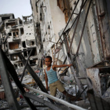 DESASTRE. Un niño palestino juega en los escombros de una torre metálica en la Franza de Gaza.
