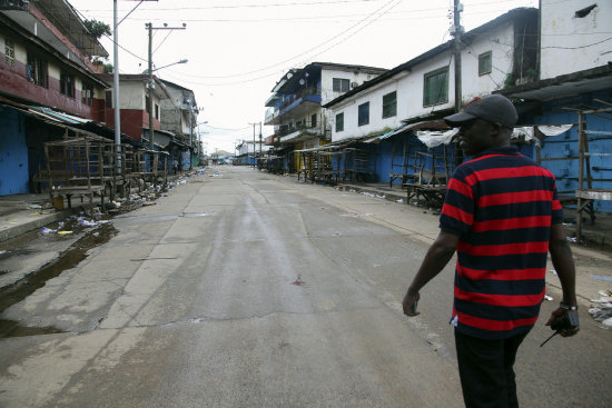 EPIDEMIA. Un oficial liberiano camina por calles desiertas con tiendas cerradas en Monrovia, Liberia, donde la situacin es grave.