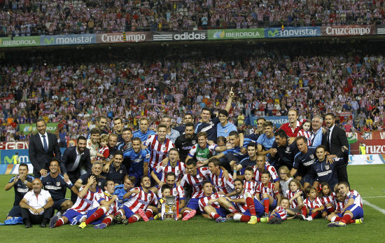 Los jugadores y el cuerpo tcnico del Atltico de Madrid celebran con la Copa tras vencer al Real Madrid por 1-0, en el partido de vuelta de la Supercopa de Espaa que se disput ayer.