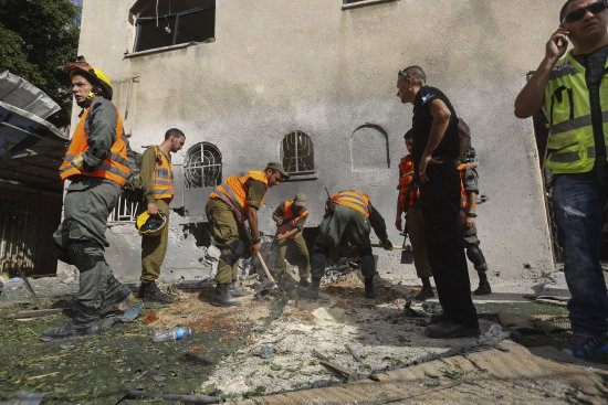 ATAQUE. Efectivos israeles observan el impacto de un cohete palestino en una sinagoga.