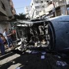 Bombardeos. Palestinos observan un automvil destrozado que fue alcanzado por una bomba en una calle de Gaza.